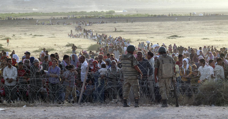 turkish-soldiers-stand-guard-syrian-refugees-wait-behind-border-fences-1